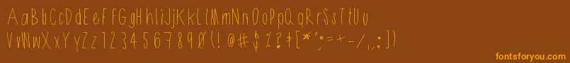 フォントShithead – オレンジ色の文字が茶色の背景にあります。