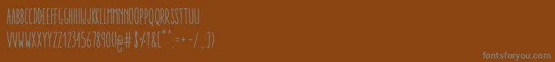 Czcionka AracneUltraCondensedRegular – szare czcionki na brązowym tle