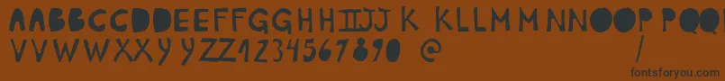 フォントPlumonCp1 – 黒い文字が茶色の背景にあります