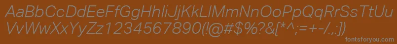 AktivgroteskcorpLightitalic-fontti – harmaat kirjasimet ruskealla taustalla