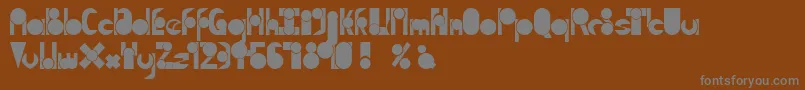 TmMoveAsideNormal-fontti – harmaat kirjasimet ruskealla taustalla