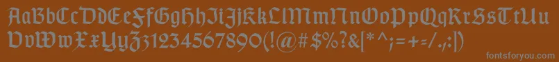 Gotischa-fontti – harmaat kirjasimet ruskealla taustalla