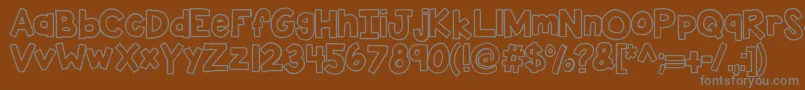Kbsticktoit-fontti – harmaat kirjasimet ruskealla taustalla