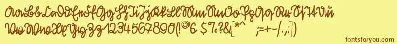 フォントKleinsfirstscript – 茶色の文字が黄色の背景にあります。
