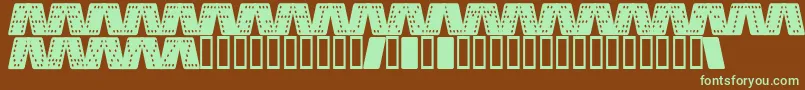 DominoSmalKursiv-fontti – vihreät fontit ruskealla taustalla
