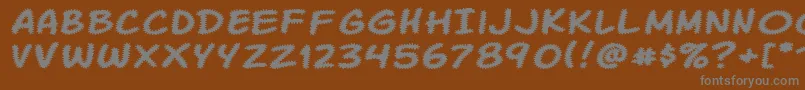 Komikatr-Schriftart – Graue Schriften auf braunem Hintergrund