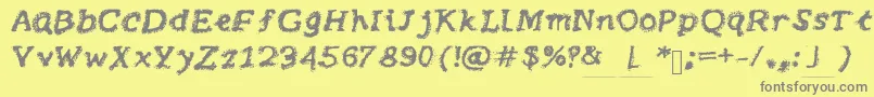 Brushy-fontti – harmaat kirjasimet keltaisella taustalla