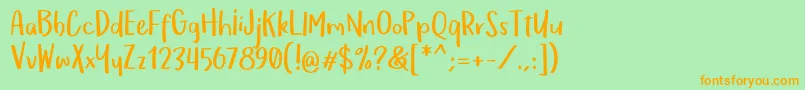 フォントOmTeloletOm – オレンジの文字が緑の背景にあります。