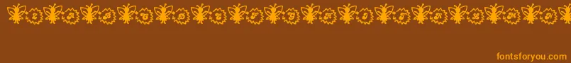 Czcionka FairySparkle – pomarańczowe czcionki na brązowym tle