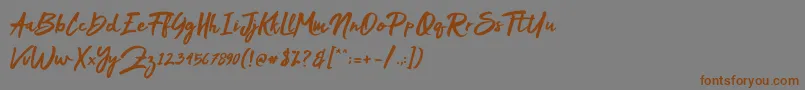 フォントMakDah – 茶色の文字が灰色の背景にあります。