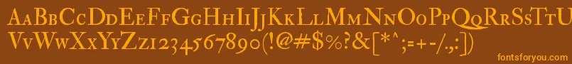 フォントImfedpsc28p – オレンジ色の文字が茶色の背景にあります。