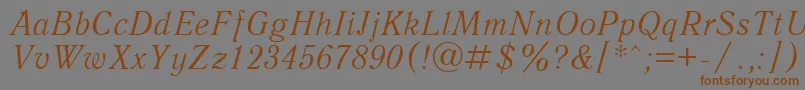 フォントUkAntiqueItalic – 茶色の文字が灰色の背景にあります。