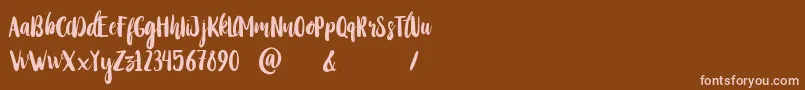 StayWildy-Schriftart – Rosa Schriften auf braunem Hintergrund
