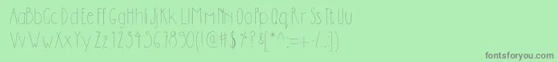 Dilemhandwritten-fontti – harmaat kirjasimet vihreällä taustalla