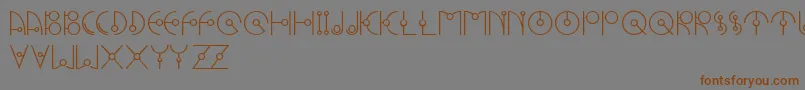 フォントUfoNestRegluar – 茶色の文字が灰色の背景にあります。