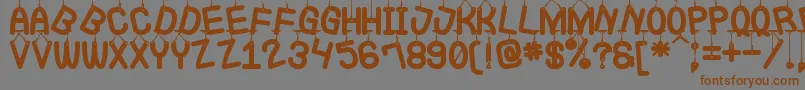 フォントLaQueCuelgaSt – 茶色の文字が灰色の背景にあります。