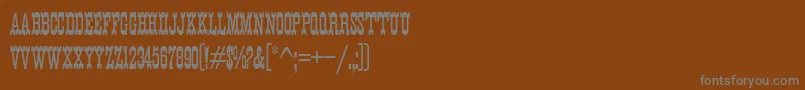K22EurekaNofrills-fontti – harmaat kirjasimet ruskealla taustalla