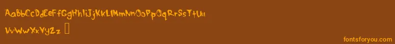 フォントDrippymcdripNm – オレンジ色の文字が茶色の背景にあります。