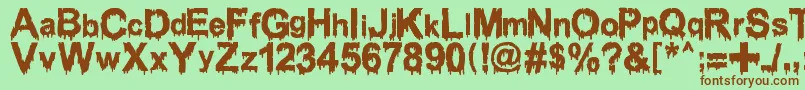 Fonte WoodcutterDrippingClassicFont – fontes marrons em um fundo verde