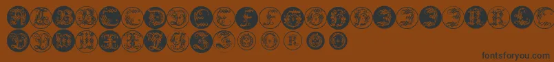 Ornamentalinitialbuttons-Schriftart – Schwarze Schriften auf braunem Hintergrund