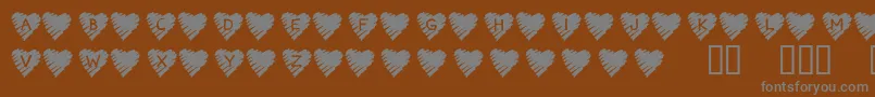 KrScribbleHeart-fontti – harmaat kirjasimet ruskealla taustalla