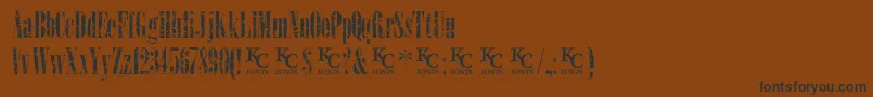 LoadupongunsKcfontsdemo-Schriftart – Schwarze Schriften auf braunem Hintergrund
