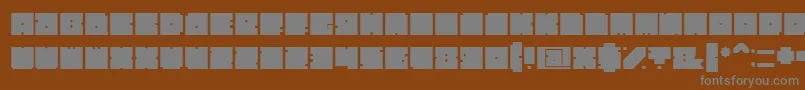 BlockBold-fontti – harmaat kirjasimet ruskealla taustalla