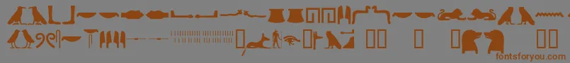 フォントEgyptianhieroglyphssilhouet – 茶色の文字が灰色の背景にあります。