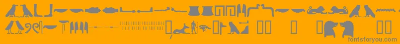 Egyptianhieroglyphssilhouet-fontti – harmaat kirjasimet oranssilla taustalla