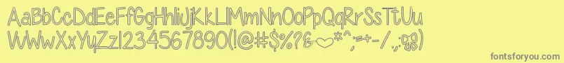 DiamondGirlHollow-fontti – harmaat kirjasimet keltaisella taustalla