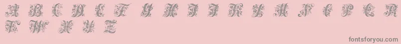 Victorianinitials1-fontti – harmaat kirjasimet vaaleanpunaisella taustalla