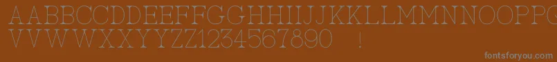 AcBigserifOne-fontti – harmaat kirjasimet ruskealla taustalla