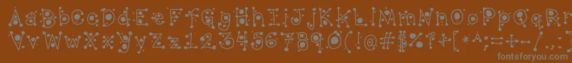 CropCircles-fontti – harmaat kirjasimet ruskealla taustalla