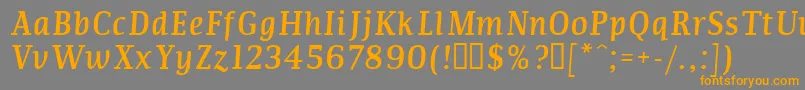 フォントCommi – オレンジの文字は灰色の背景にあります。