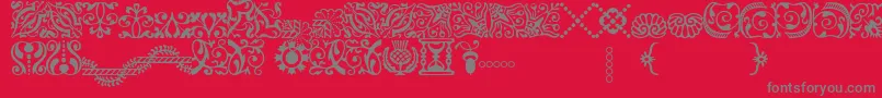 AdobeCaslonOrnaments-fontti – harmaat kirjasimet punaisella taustalla