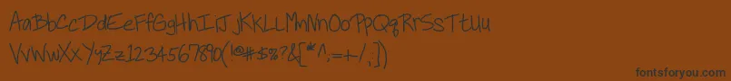 フォントKbneiledit – 黒い文字が茶色の背景にあります