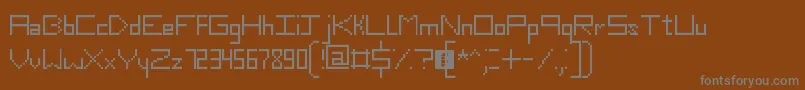 SlimThirteenPixelFonts-fontti – harmaat kirjasimet ruskealla taustalla