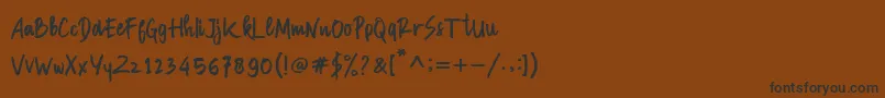 フォントManksa – 黒い文字が茶色の背景にあります