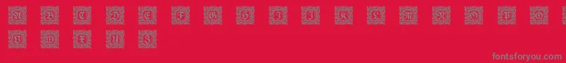 フォントSchmuckinitialen2 – 赤い背景に灰色の文字