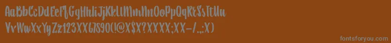 DkAiguille-fontti – harmaat kirjasimet ruskealla taustalla