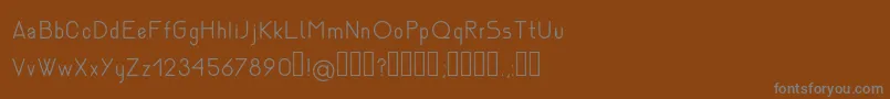 NemesiaLight-fontti – harmaat kirjasimet ruskealla taustalla