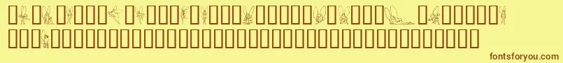 フォントSlWoodcutFaeries – 茶色の文字が黄色の背景にあります。