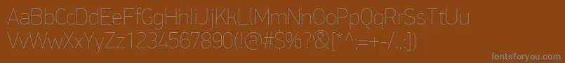 Fonte PfdindisplayproExtrathin – fontes cinzas em um fundo marrom
