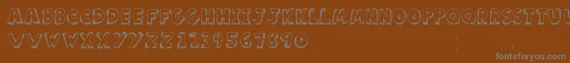 ScoolarTfb-fontti – harmaat kirjasimet ruskealla taustalla