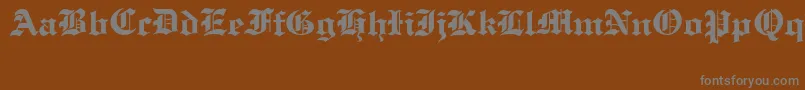 OldCologneRegular-Schriftart – Graue Schriften auf braunem Hintergrund