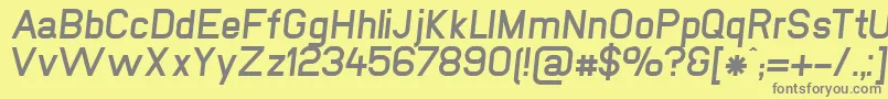 NewmediaFettKursiv-fontti – harmaat kirjasimet keltaisella taustalla