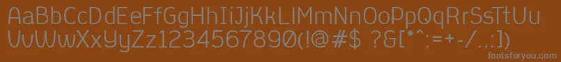 AleksandracVintage-fontti – harmaat kirjasimet ruskealla taustalla