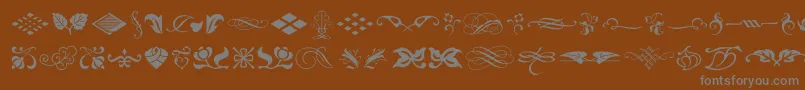 Czcionka TypeEmbellishmentsOneLetPlain.1.0 – szare czcionki na brązowym tle