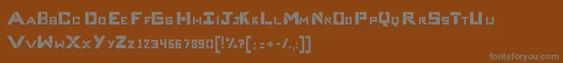 CompliceBold-fontti – harmaat kirjasimet ruskealla taustalla