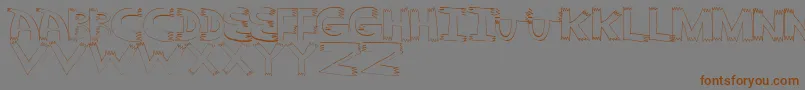 フォントPointy – 茶色の文字が灰色の背景にあります。